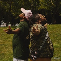 two men standing in a park with a frisbee in their hands